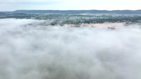 Una-Hermosa-Vista-Aérea-Del-Paisaje-Cubierto-De-Niebla-A-Primera-Hora-De-La-Mañana