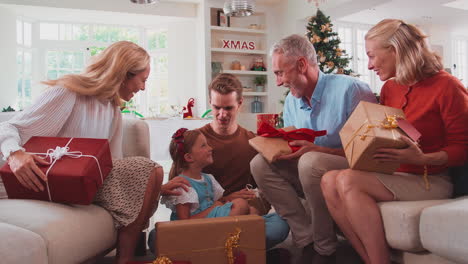 Multi-Generation-Family-Celebrating-Christmas-At-Home-Opening-Presents-Together