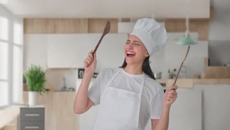 excited indian female professional chef dancing and enjoying