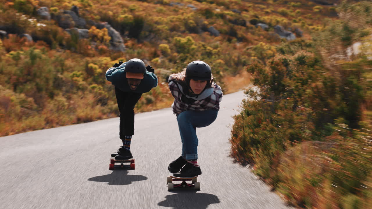 젊은 친구 들 이 함께 롱보드 를 즐기고 경쟁 경주 를 즐기고 빠른 내리막길 을 즐기고 스케이트 보드 를 타고 보호 헬 ⁇  을 착용 하고 여름 휴가 스포츠 를 즐기고