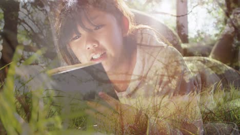 animation of grass over happy asian woman reading book