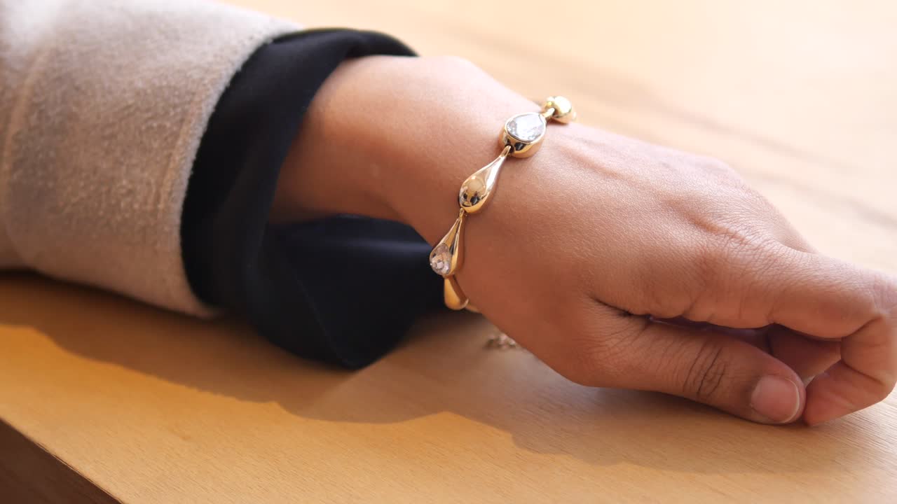 Woman Wearing Gold Bracelet with Diamonds