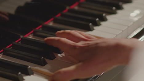 hands of man playing piano