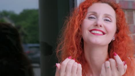 a lively redheaded woman joyfully blowing affectionate kisses showcasing her bold and bright red a lively redheaded woman joyfully blowing affectionate kisses showcasing her bold and bright red nails