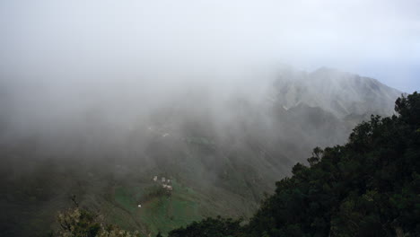 Timelapse-of-fog-flowing-over-a-mountain-range-with-the-ocean-in-the-background