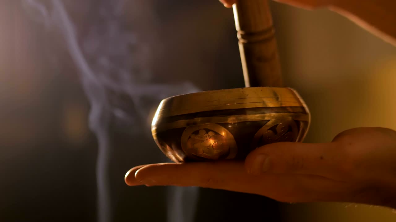 hombre tocando en el cuenco de canto tibetano