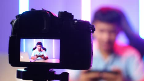 display camera of asian kid boy playing video game with mobile phone then celebrating while live stream