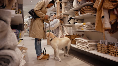 a young girl shops with her emotional support yellow labrador on a leash at a dog-friendly mall