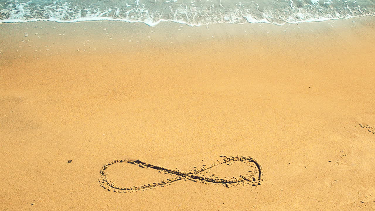 Sign infinity on sand, the beach. Shooting on the beach