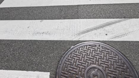 manhole cover appears on pedestrian crossing