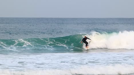 Cámara-Lenta-De-Surfista-Profesional-Con-Casco-Blanco-Atacando-El-Labio-Con-Fuerza-Y-Poder-En-Cascais,-En-El-Guincho