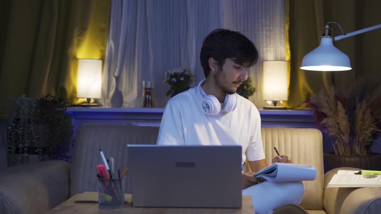 남성 학생이 밤에 숙제를 끝내려고 합니다.