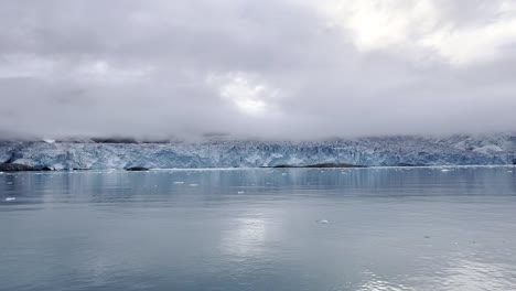 glacier overview reflected in the icy water in the arctic sea during an expedition boat trip in svalbard