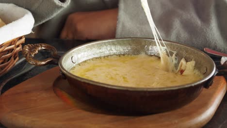 preparing melted cheese in a pan