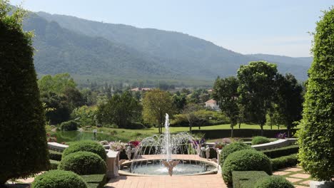 hermoso jardín con fuente y fondo de montaña