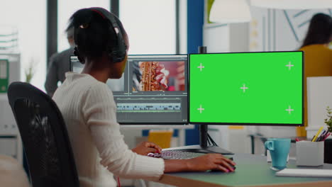 african woman videographer with headset processing film montage