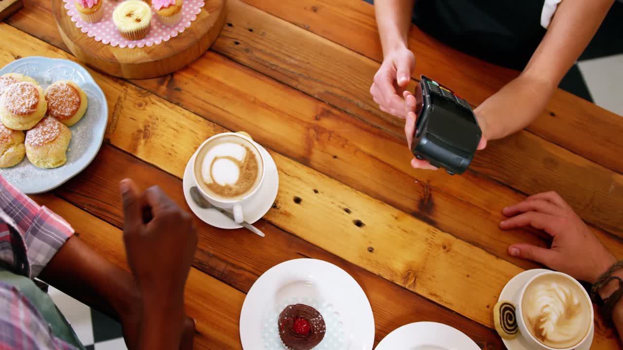 cliente que realiza un pago a través de una máquina terminal de pago en el mostrador