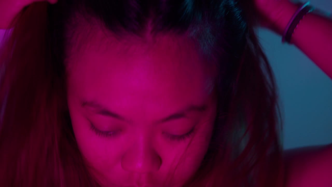 Close-up Portrait of a Young Woman with Neon Pink and Blue Lighting