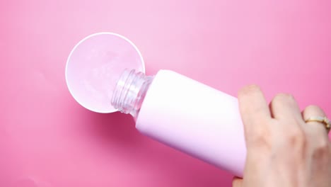 pouring water from pink water bottle into pink cup