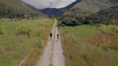 sporty couple runs along dirt road through rural landscape