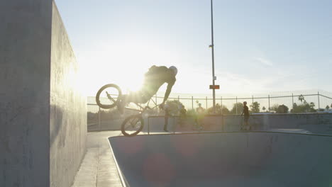 bmxer doing tricks in skatepark