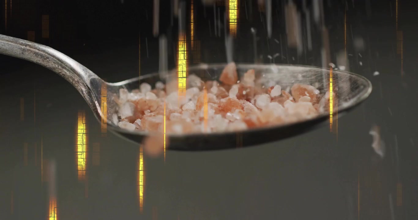 Gold streaks appearing salt grains falling into metal spoon hitting bouncing building bigger pile