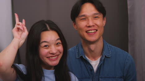 사진 상자 에 있는 부부 는 초상화 를 위해 포즈 를 취 하고 실시간 으로 얼굴 을 찍는 것 을 즐기고 있다