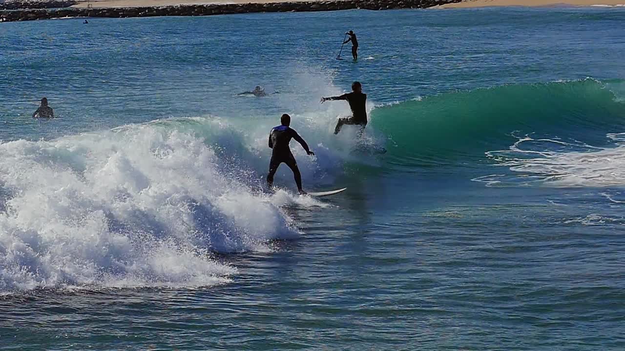 Slow motion (120fps): male surfer surfing the wave  in Barcelona, Spain