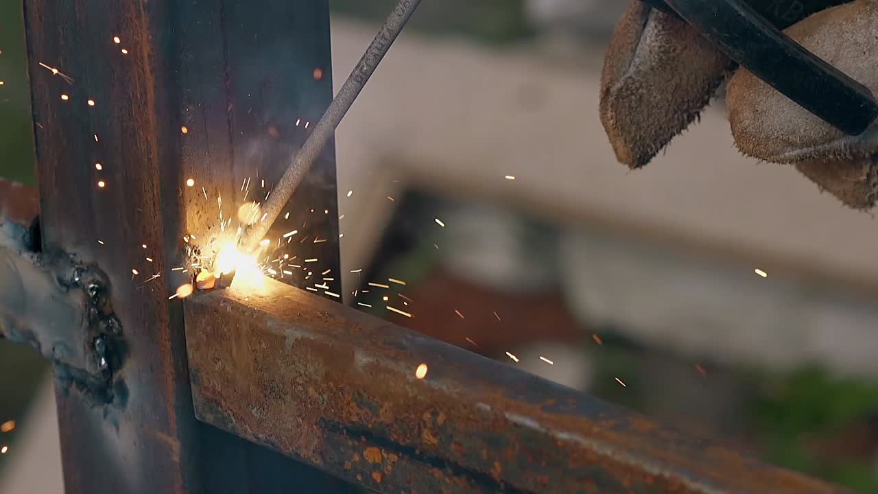 금속 울타리에서 용접 기계와 함께 근접 보기 빌더 작업