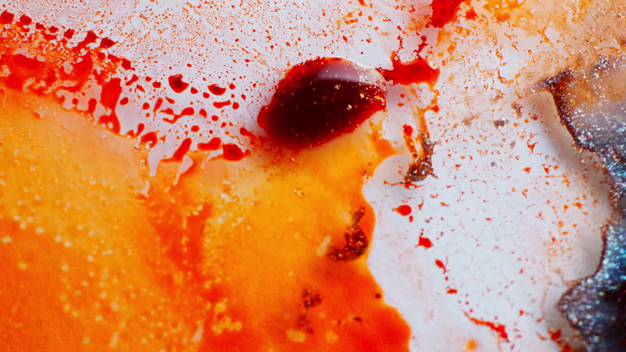 Orange ink in motion creating artistic shapes on a white background. Macro