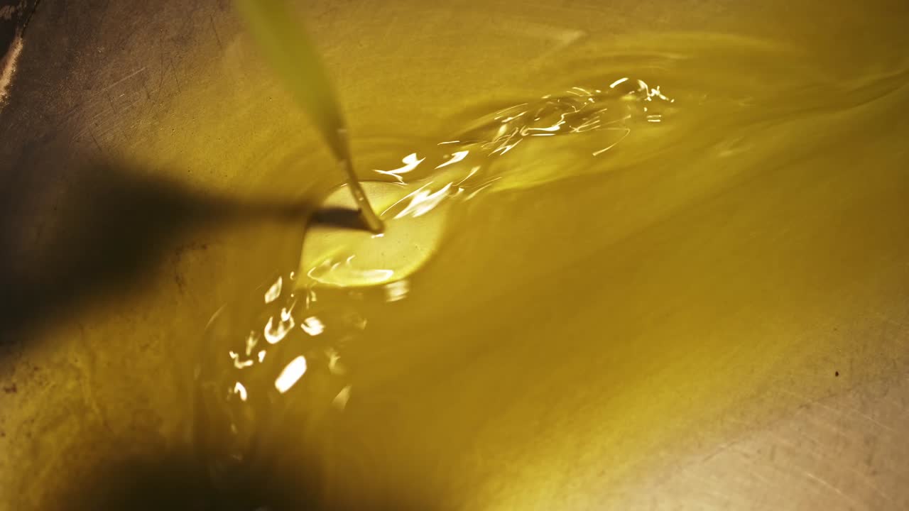 Olio d'oliva dorato che scorre fluidamente durante la lavorazione in Portogallo.