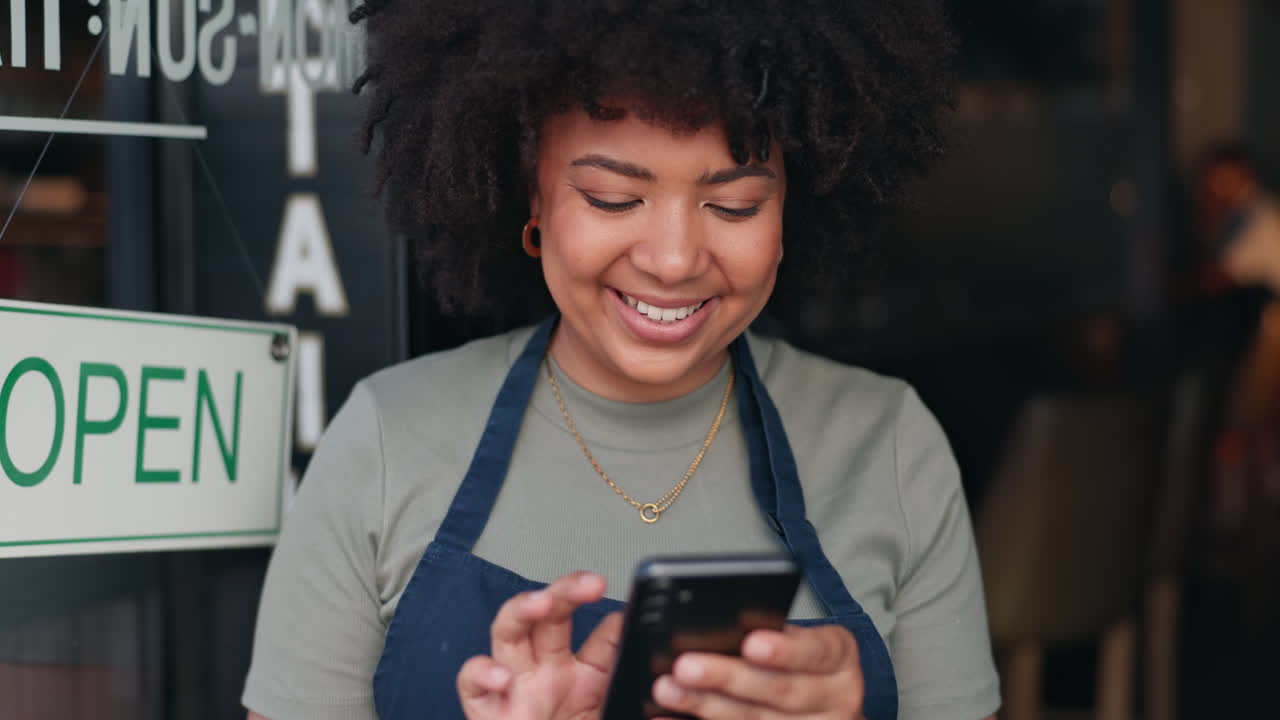 Woman Working at a Cafe Using a Smartphone