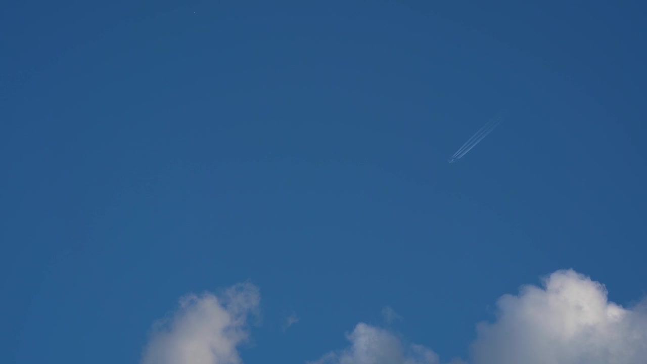 Aereo che vola nel cielo blu lasciando scie bianche ed entra tra le nuvole bianche, concetto di viaggio