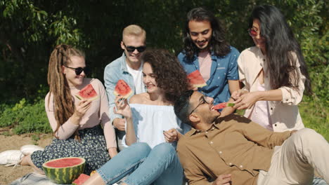 friends enjoying a watermelon picnic