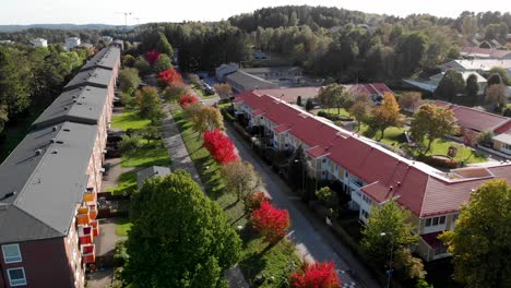 rising drone shot of terraced row of houses surrounded by autumn coloured trees