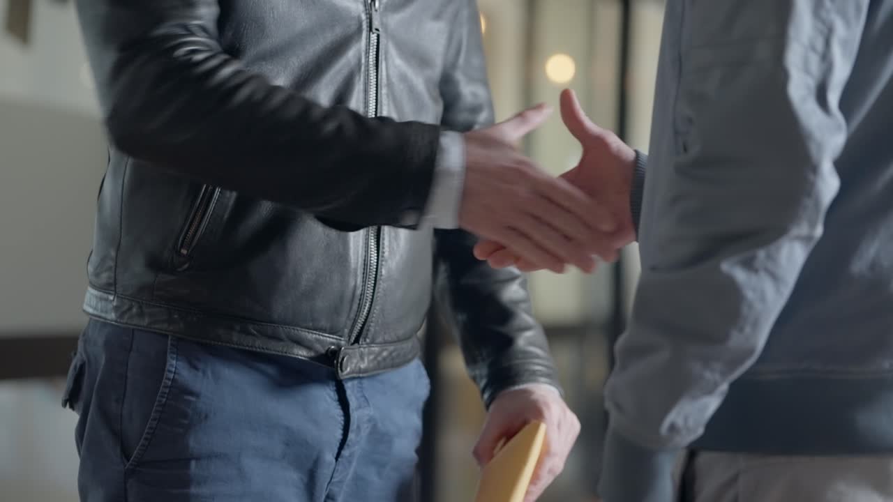 Shady business transaction in office. Two men exchange briefcase with envelope of money and shake hands. Corruption or conspiracy fraud. Payoff for criminal activity or bribe in corporate setting