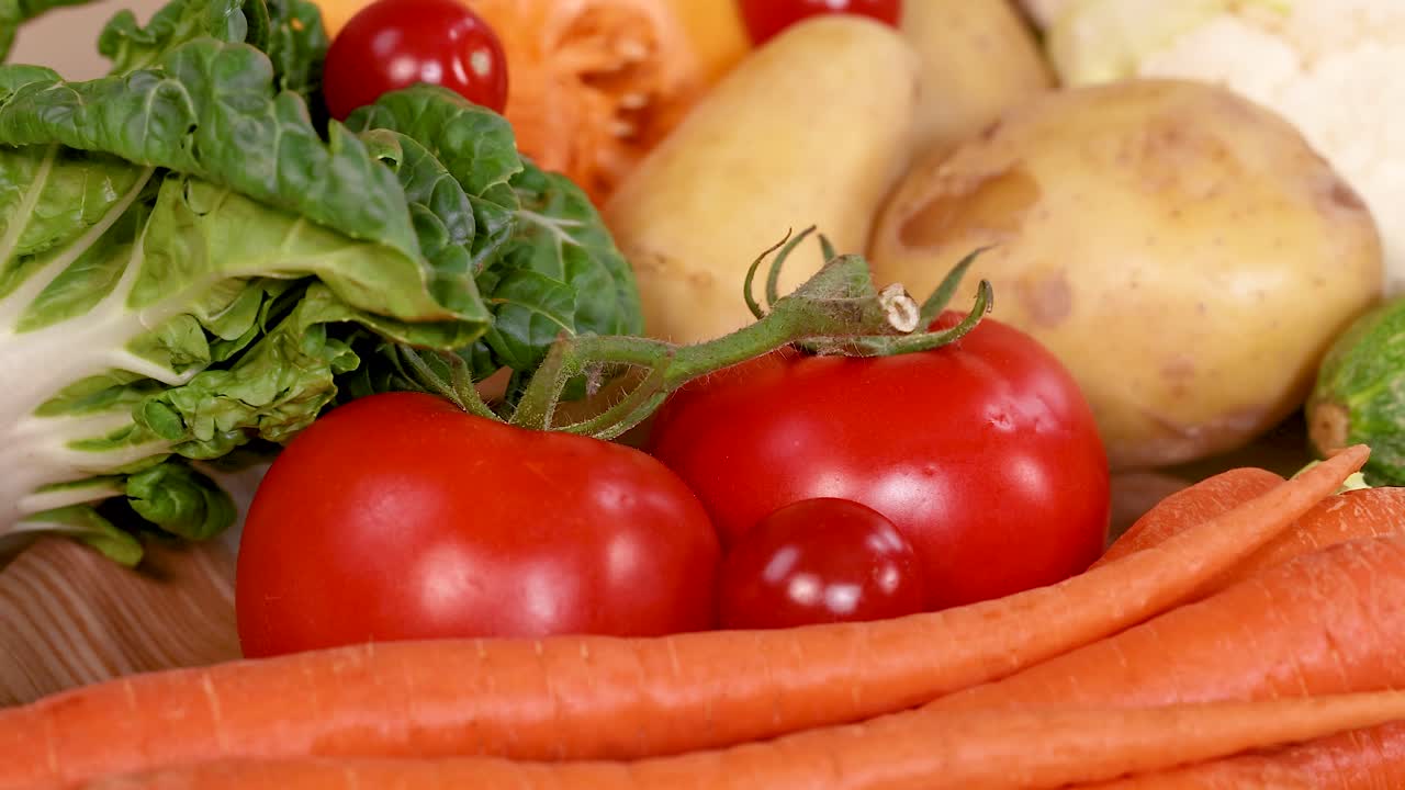 A vibrant assortment of fresh vegetables including tomatoes, carrots, and zucchini, showcasing organic produce in natural lighting