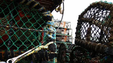 stacked empty fishing industry lobster net mesh baskets closeup dolly right