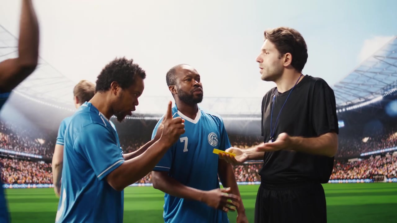 Arbitro di calcio che interrompe un'accesa discussione con il cartellino giallo alzato.