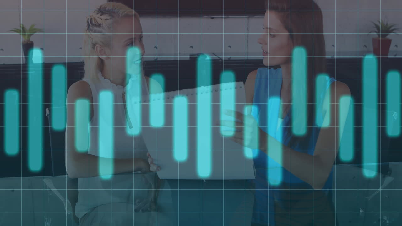 Two women colleagues discussing strategy in office, with animated laptop chart and grid lines