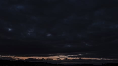 rushing hyperlapse post apocalyptic storm clouds over a distant body of dark water at sunrise, pan left dolly out
