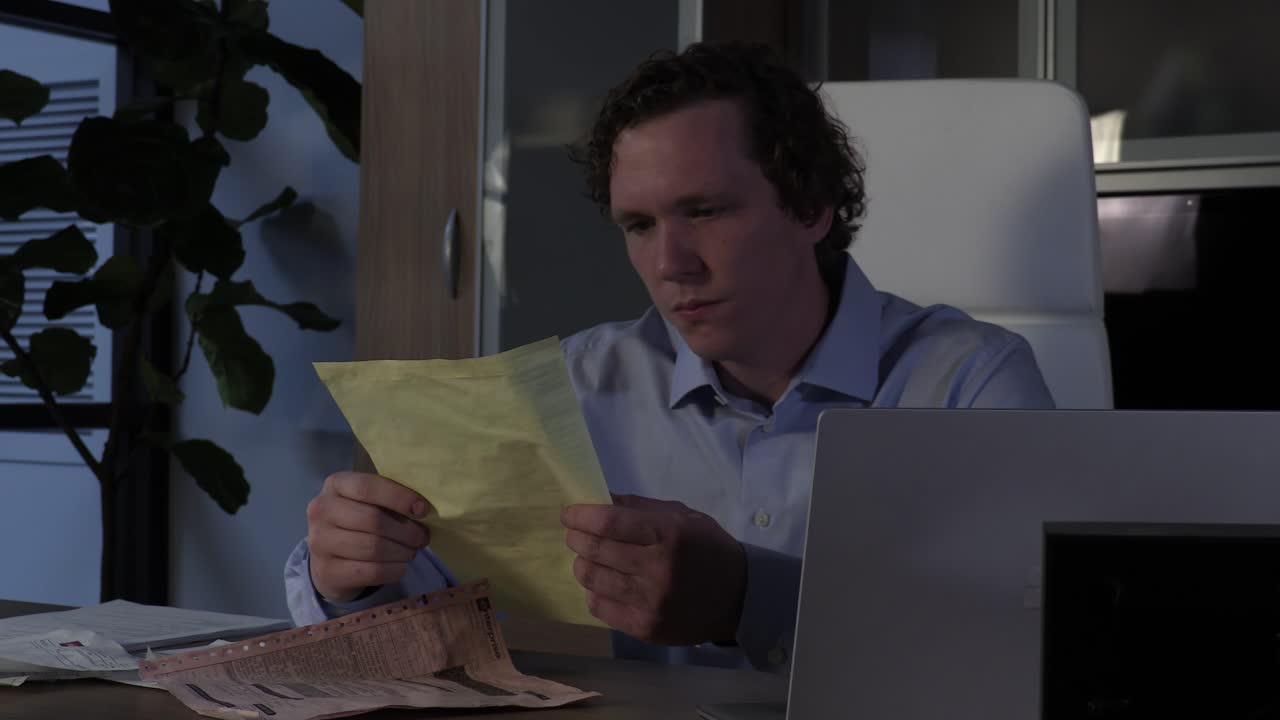 empleado de oficina con exceso de trabajo y estresado trabajando hasta tarde