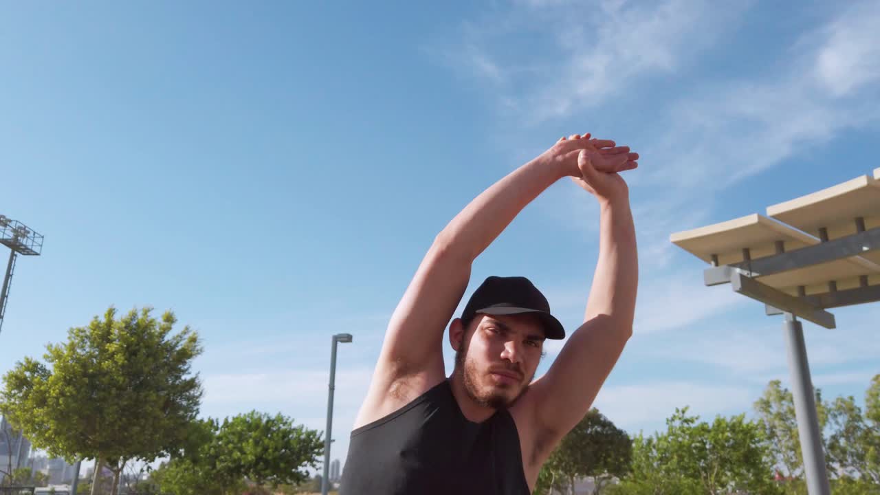Young men warming up exercises. Stretching arms.