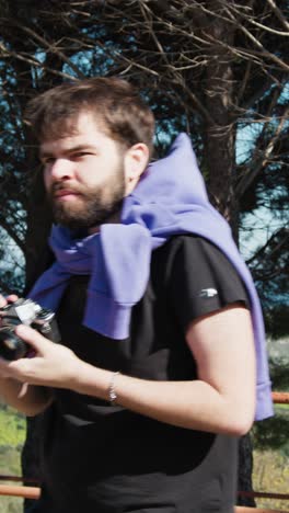 boy in the park taking photos with his vintage camera