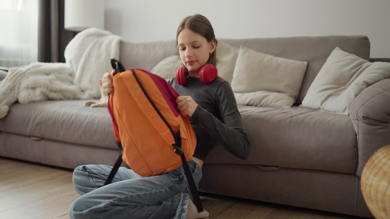 Girl Packing Backpack on Floor