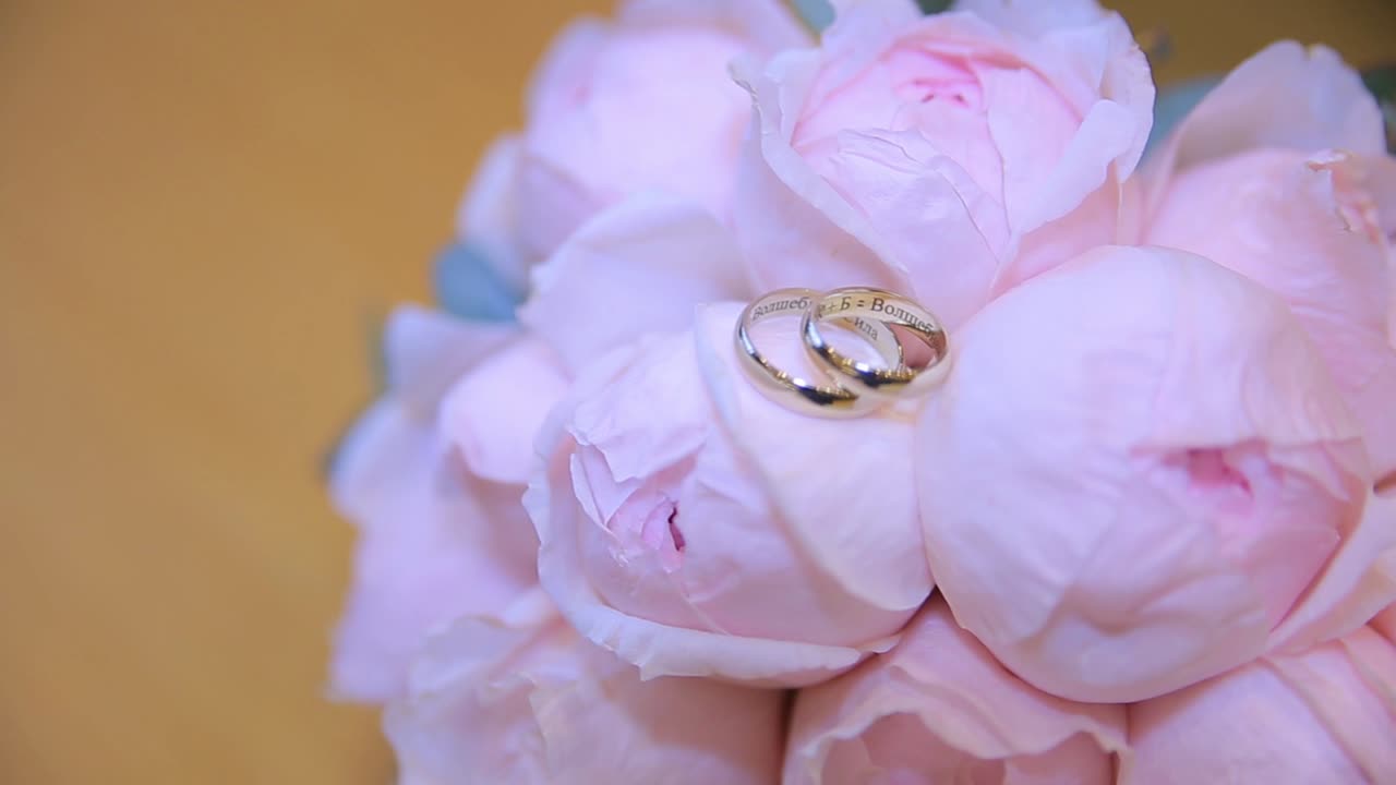 Wedding Rings on a Bouquet of Pink Roses