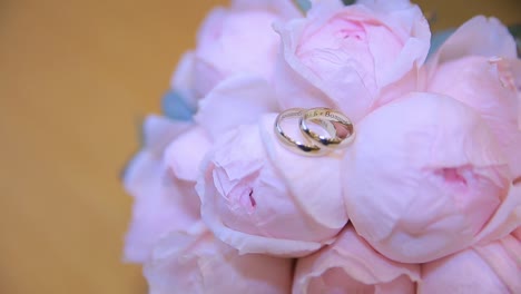 anillos de bodas en un ramo de rosas rosas