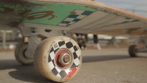 a skateboard with checkered wheels in the middle of a skate park