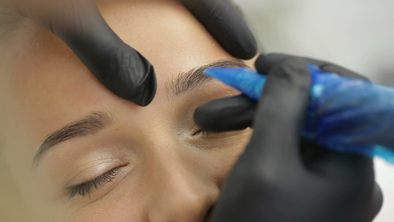 Permanent Makeup Eyebrows. Cosmetologist applying a special permanent makeup on eyebrows