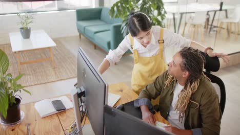 busy diverse casual business colleagues using computer and discussing work in office, slow motion